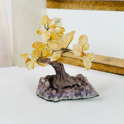 citrine tree of amethyst base with decorations in the background