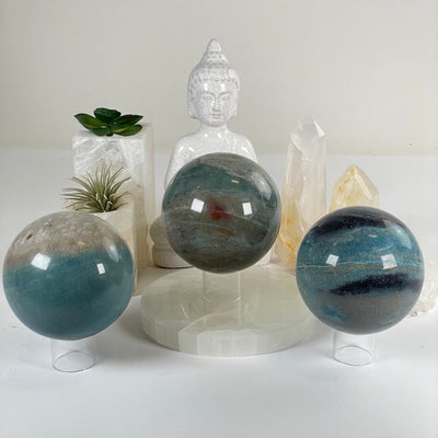 Trolleite Large Crystal Sphere - You Choose #2 all variants front view with props and plants in the background