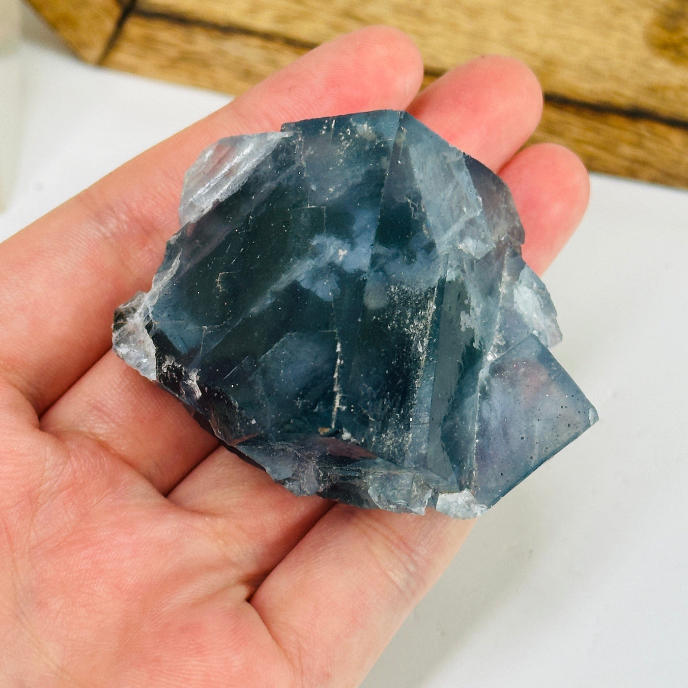 Blue fluorite crystal with decorations in the background