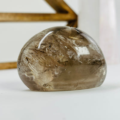 polished smokey quartz with decorations in the background