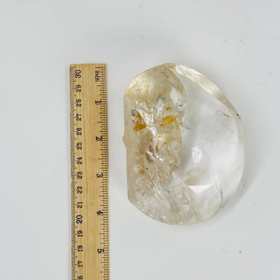 crystal quartz with inclusions next to a ruler for size reference