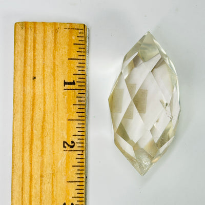 crystal quartz point next to a ruler for size reference