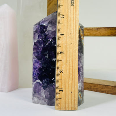 amethyst point next to a ruler for size reference