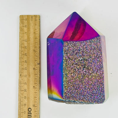 rainbow titanium agate druzy point next to a ruler for size reference