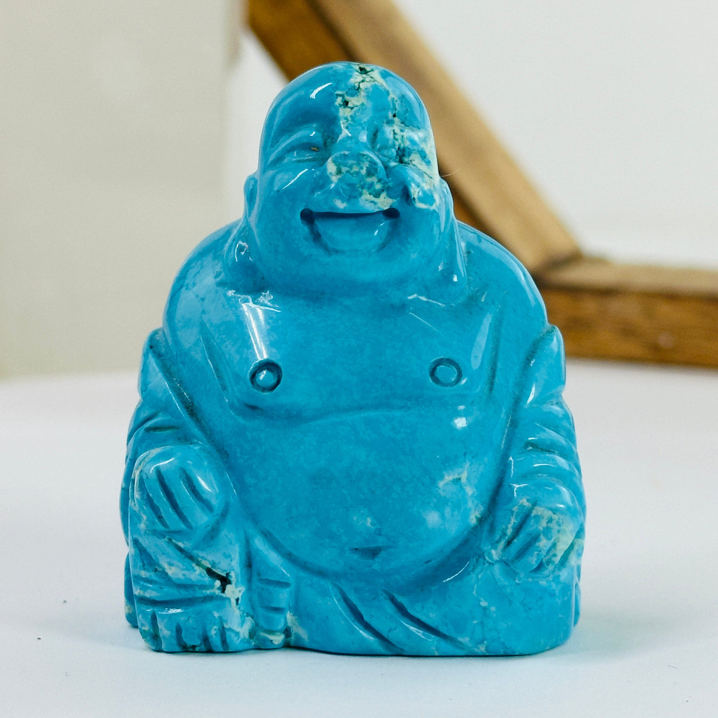 blue howlite buddha statue with decorations in the background