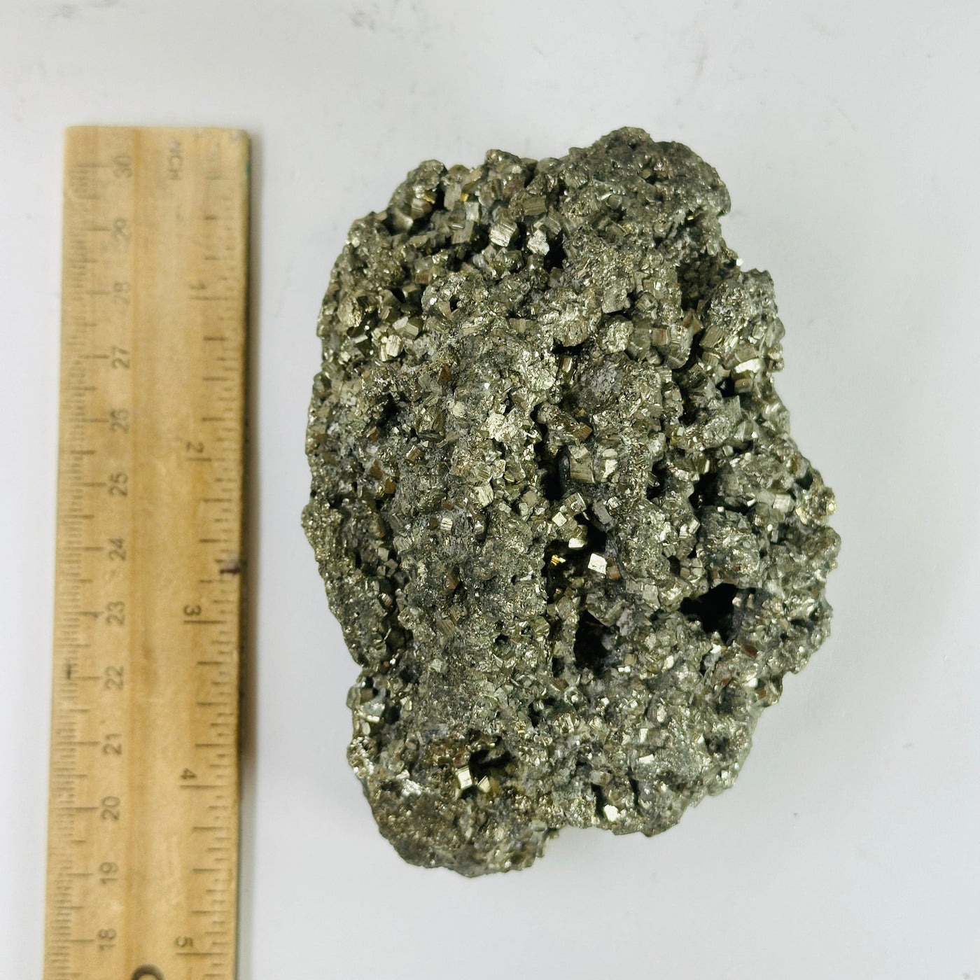 pyrite cluster next to a ruler for size reference