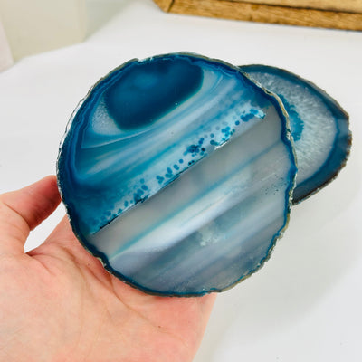 Teal agate coaster with decorations in the background