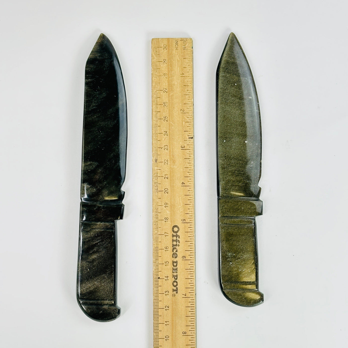 obsidian knives next to a ruler for size reference
