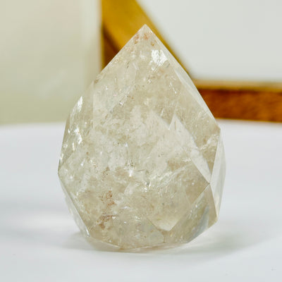 crystal quartz point with decorations in the background