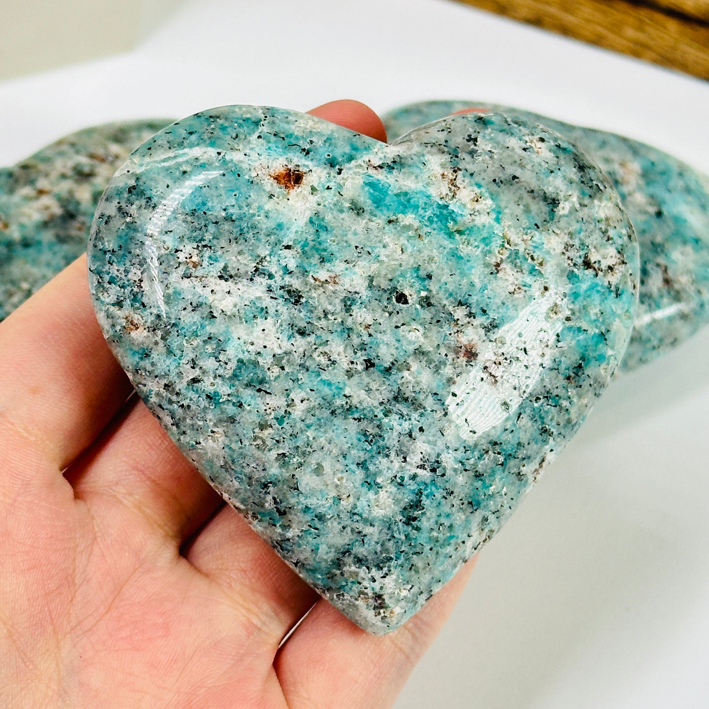 amazonite heart with decorations in the background