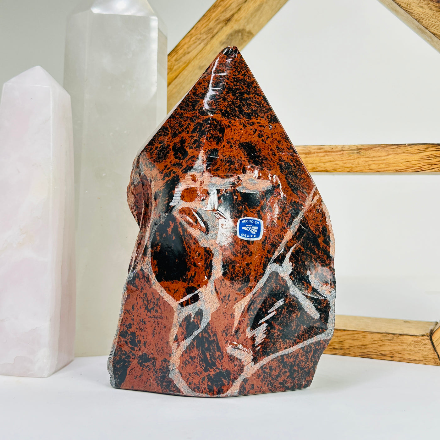 mahogany obsidian point with decorations in the background