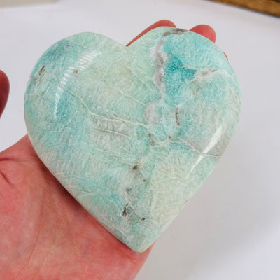 blue aragonite heart with decorations in the background
