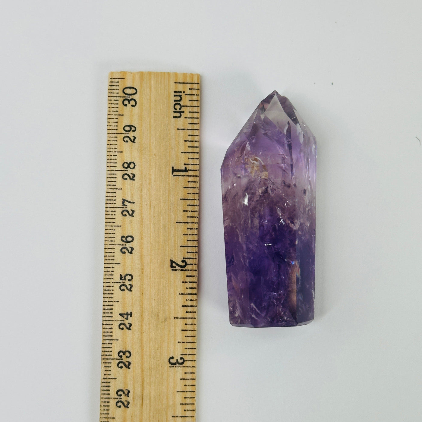 amethyst polished point next to a ruler for size reference