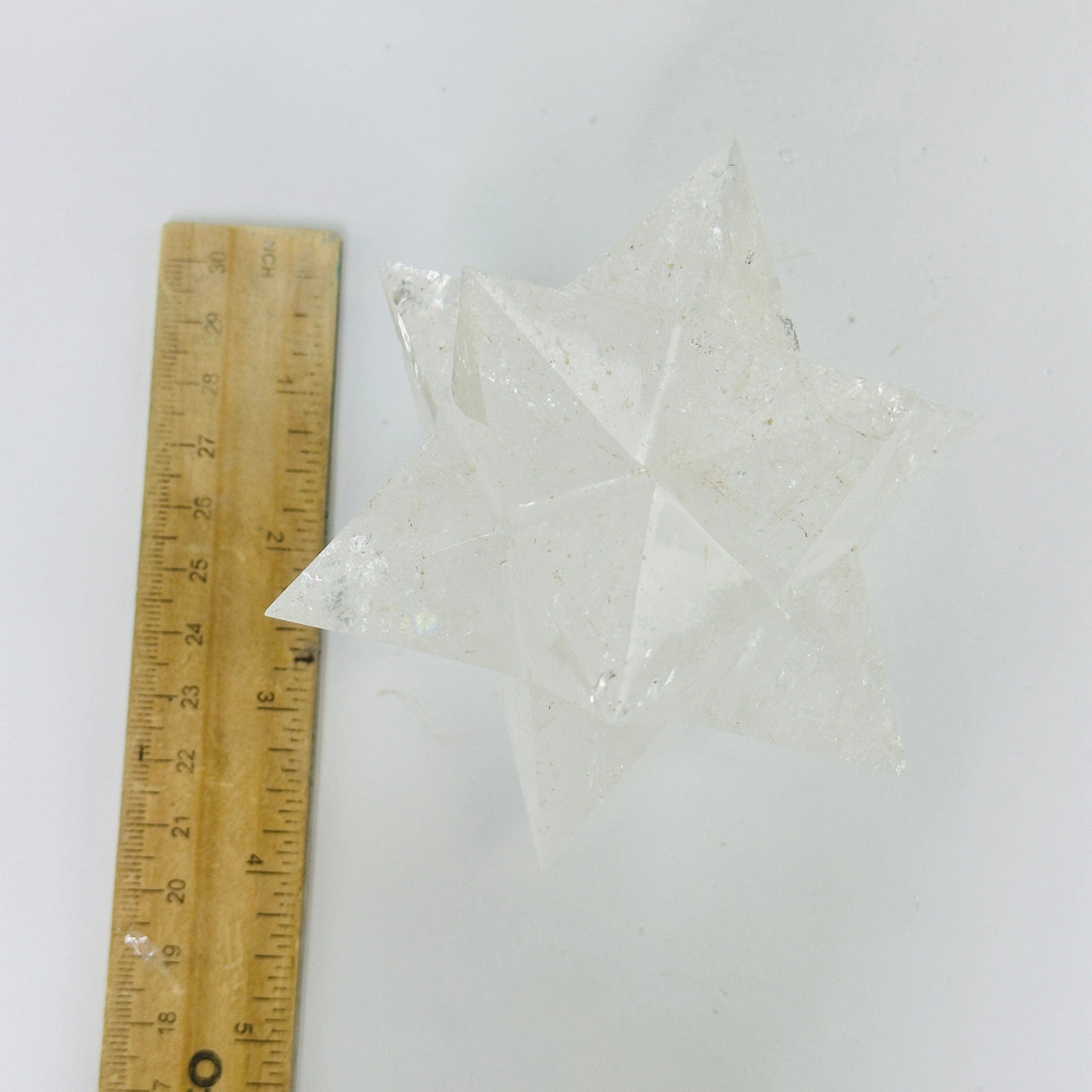 crystal quartz merkaba next to a ruler for size reference