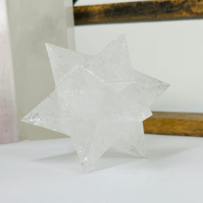 crystal quartz merkaba with decorations in the background