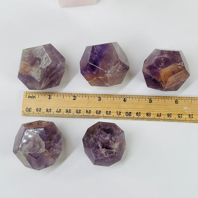 amethyst dodecahedron next to a ruler for size reference