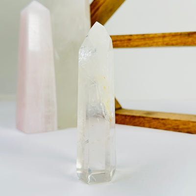 crystal quartz point with decorations in the background