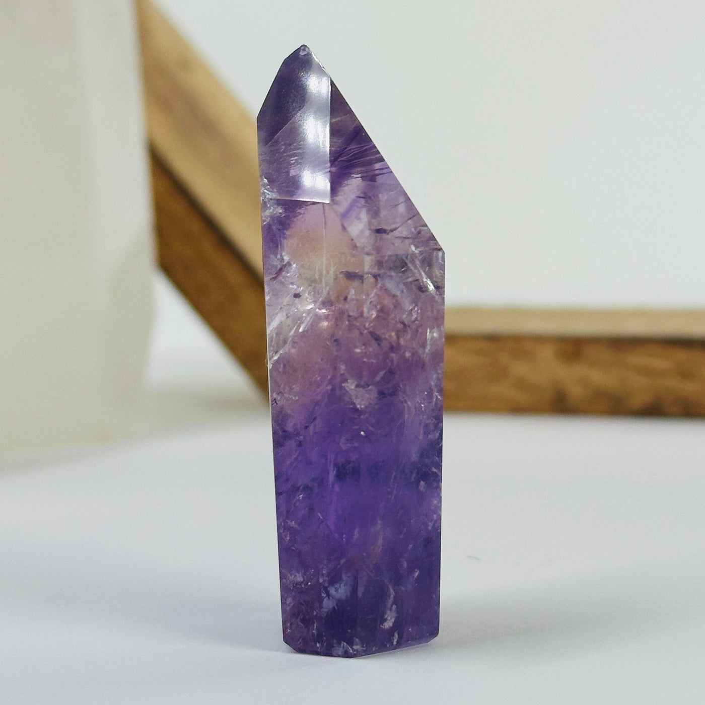 amethyst polished point with decorations in the background