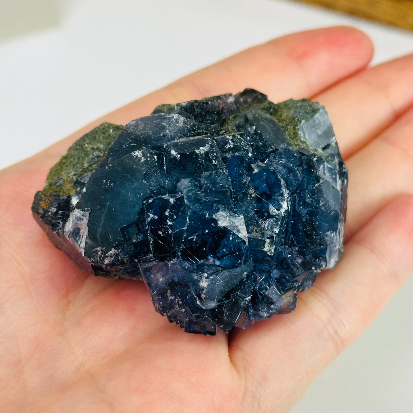 Blue fluorite crystal with decorations in the background