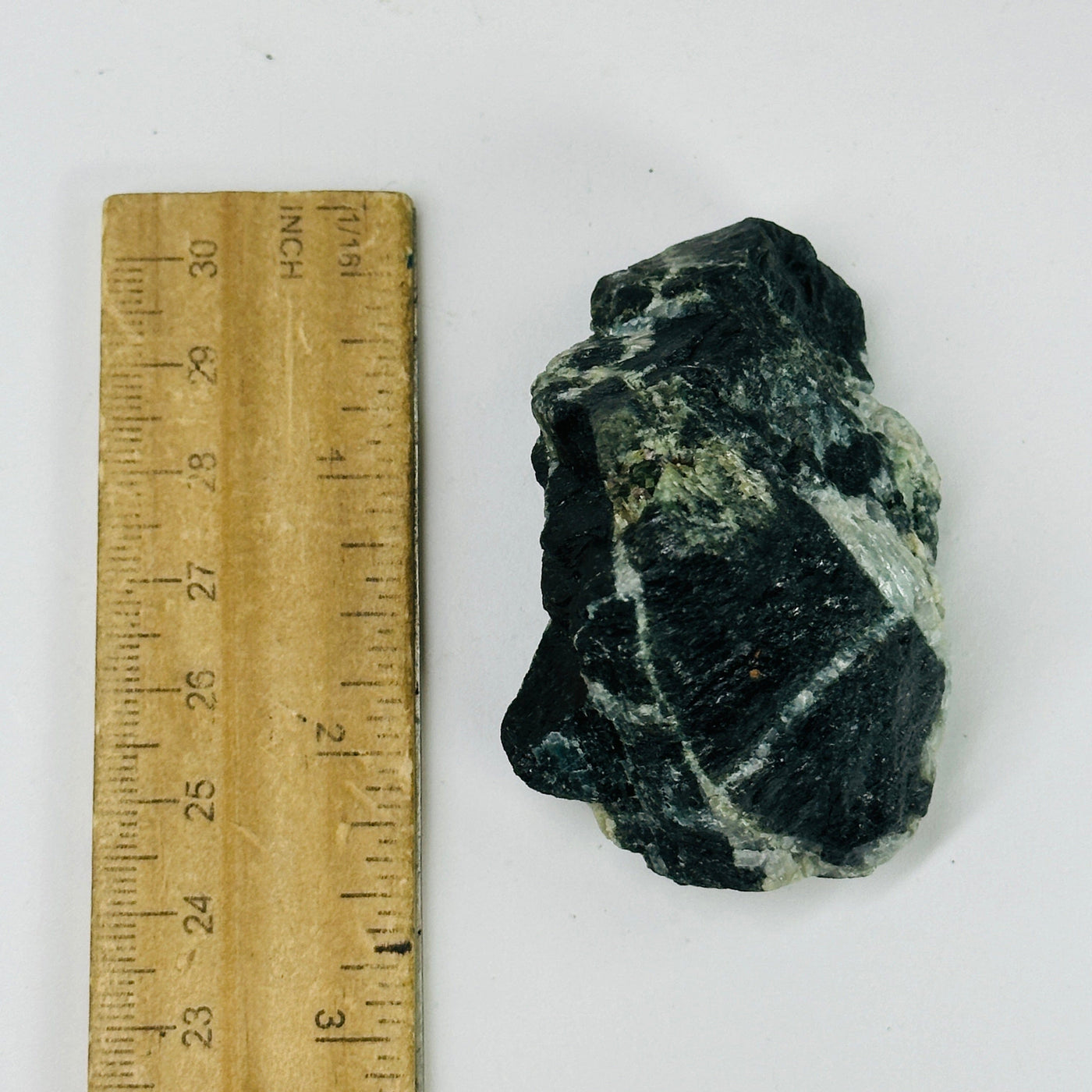 tourmaline next to a ruler for size reference