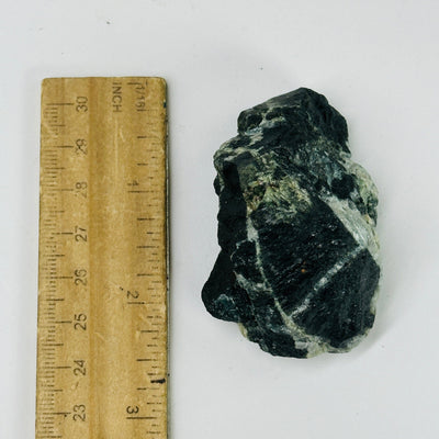 tourmaline next to a ruler for size reference