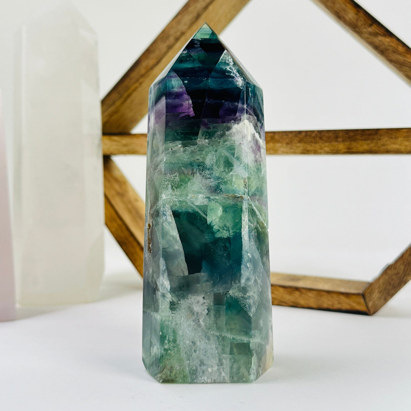 fluorite polished point with decorations in the background
