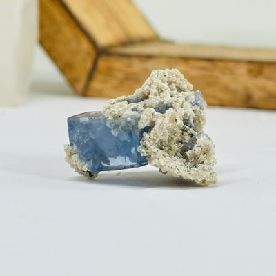 Blue fluorite crystal with decorations in the background