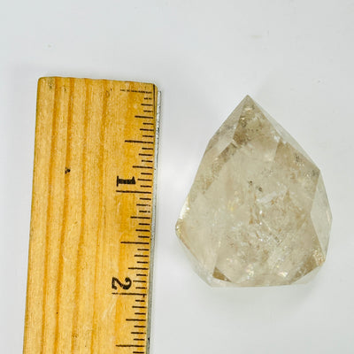 crystal quartz point next to a ruler for size reference