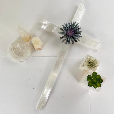 Selenite Blue Kyanite and Amethyst Crystal Cross Wall Hanging - One-of-a-Kind top view with props and plants