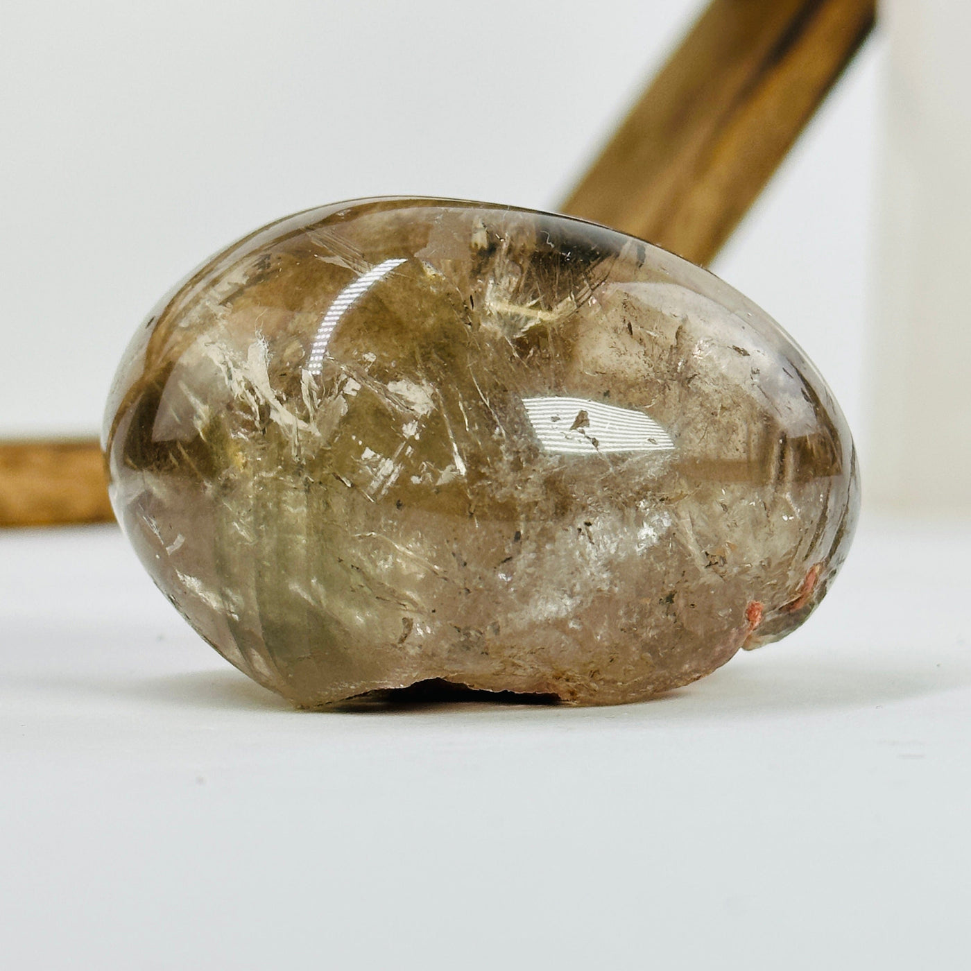 polished smoky quartz with decorations in the background