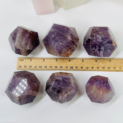 amethyst dodecahedron next to a ruler for size reference