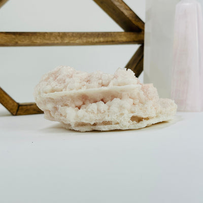 pink halite cluster with decorations in the background