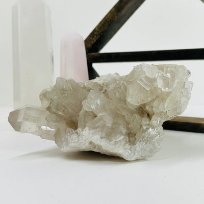 crystal quartz cluster with decorations in the background