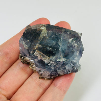 Blue fluorite crystal with decorations in the background