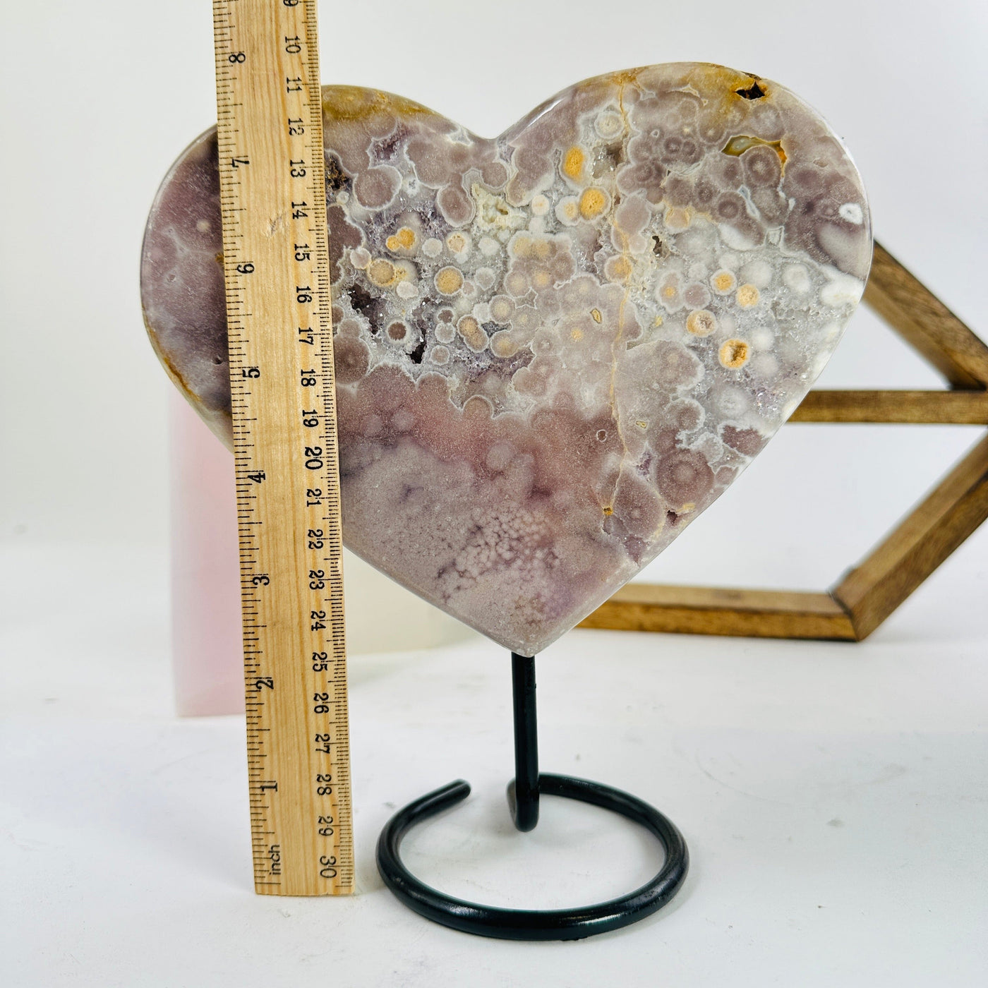 pink amethyst on stand next to a ruler for size reference