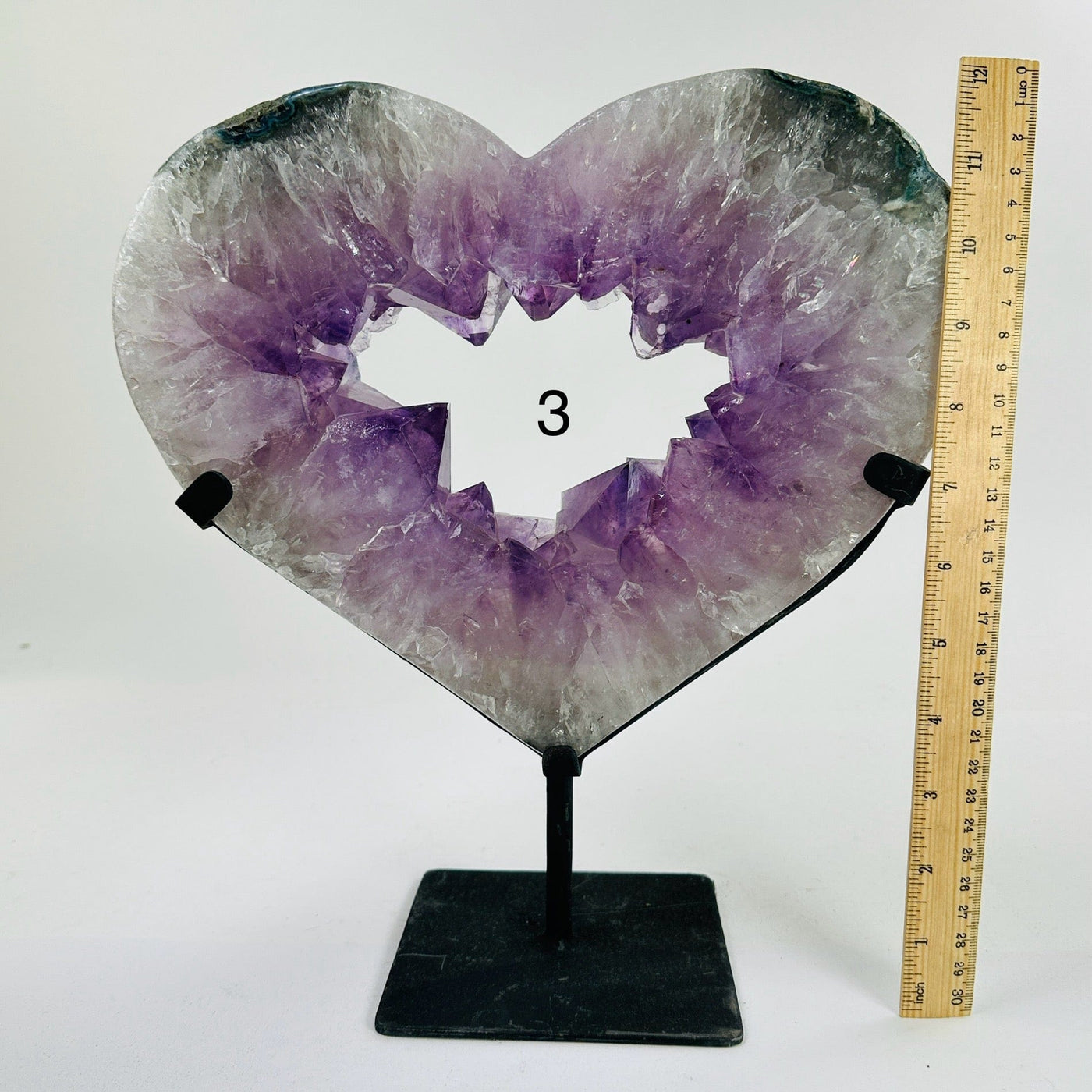 amethyst heart on stand next to a ruler for size reference
