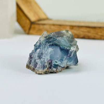 Blue fluorite crystal with decorations in the background