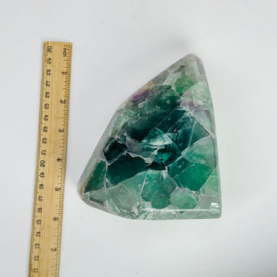 rainbow fluorite cut base next to a ruler for size reference