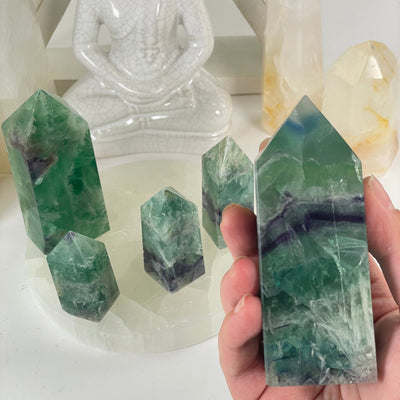 Rainbow Feathered Fluorite Crystal Point - You Choose one variant in hand for size reference with other variants in the background with props