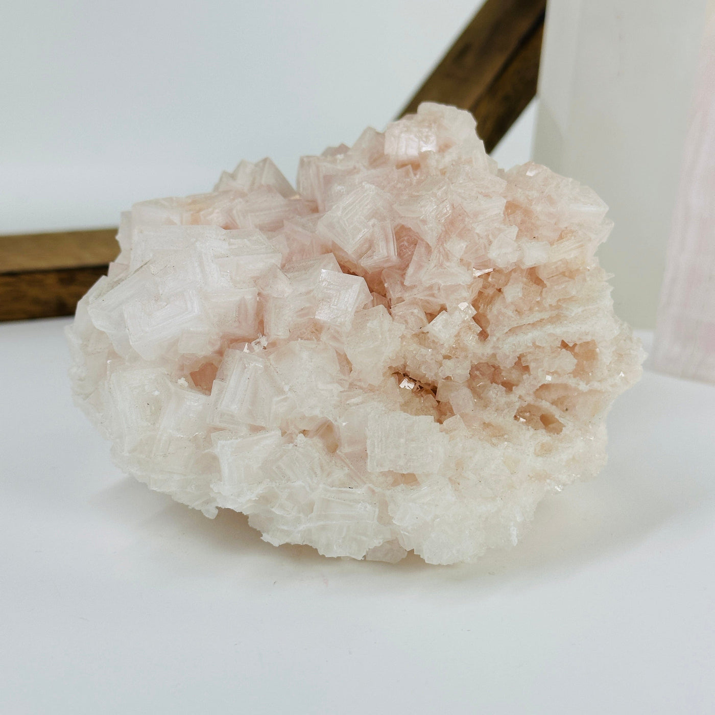 pink halite cluster with decorations in the background