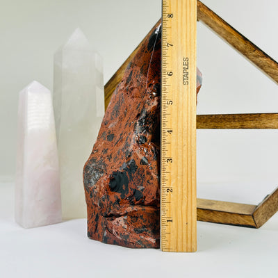 mahogany obsidian point next to a ruler for size reference