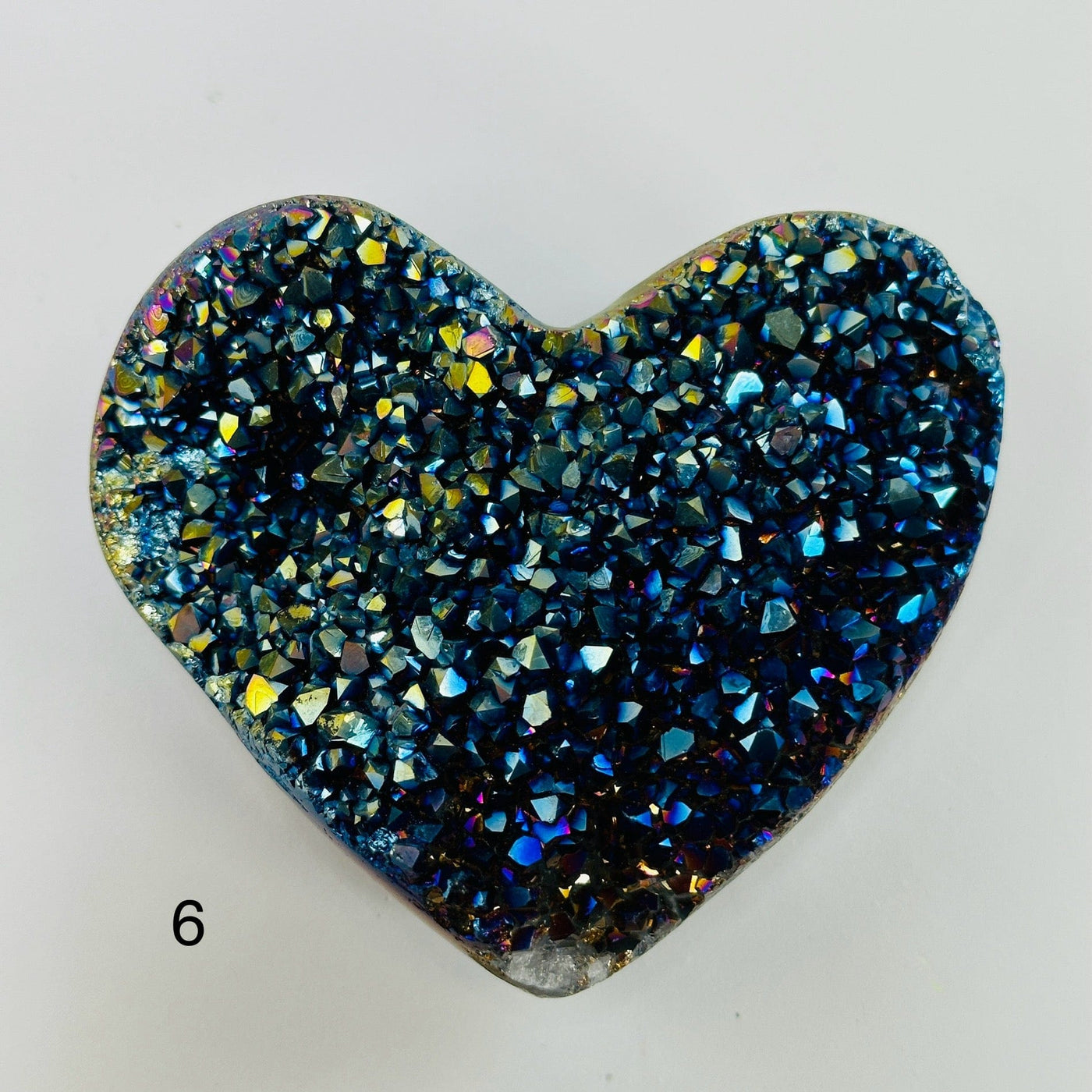 Rainbow titanium heart with decorations in the background