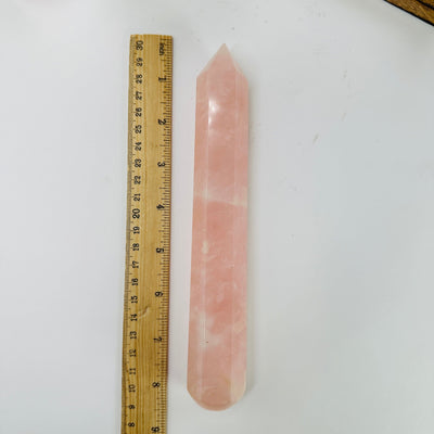 rose quartz massage wand next to a ruler for size reference