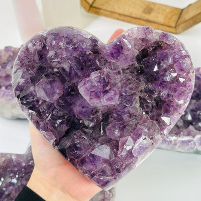amethyst crystal heart with decorations in the background