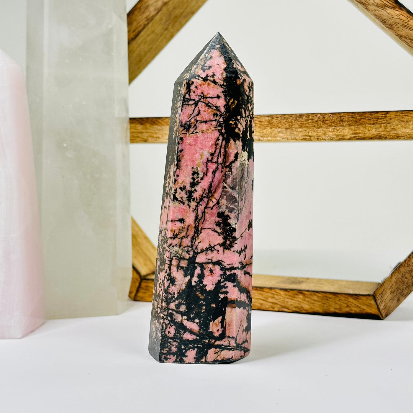 rhodonite point with decorations in the background