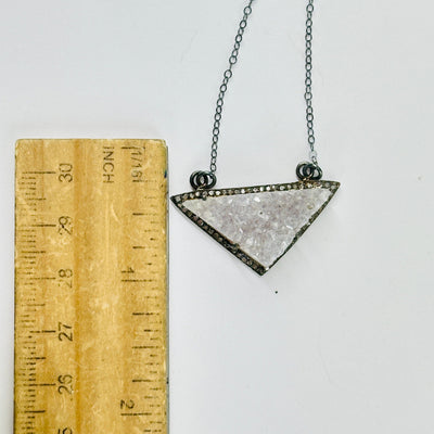 druzy pendant necklace next to a ruler for size reference