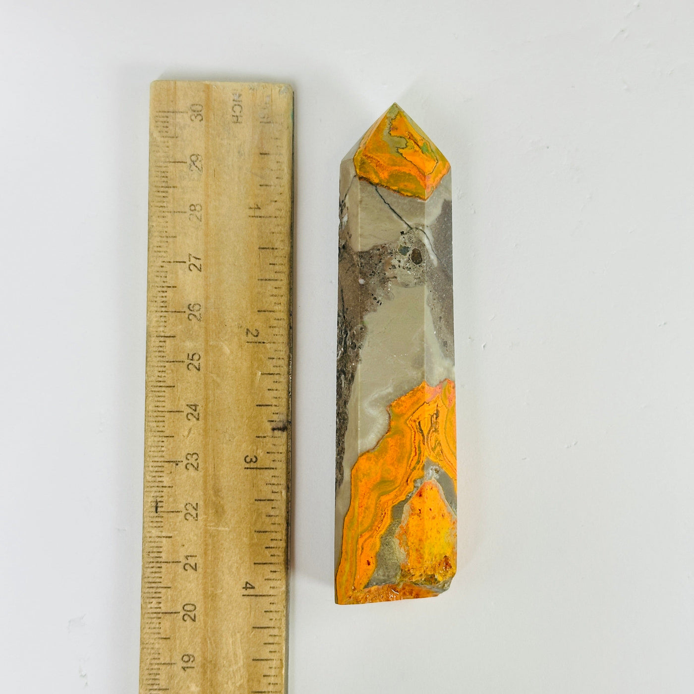 bumble bee jasper point next to a ruler for size reference