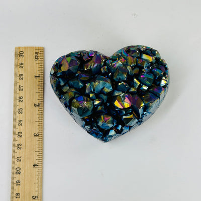 rainbow titanium coated heart next to a ruler for size reference