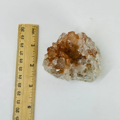 tangerine quartz cluster next to a ruler for size reference