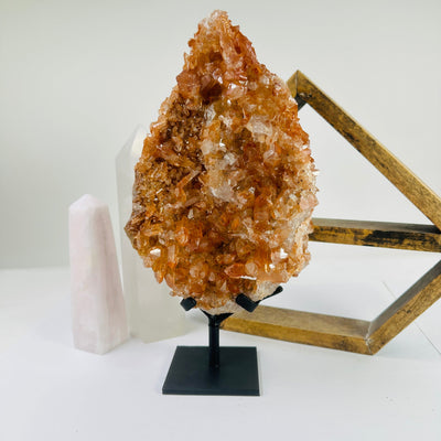 tangerine quartz on stand with decorations in the background